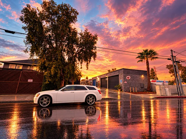 White Dodge Magnum wagon on a rain-soaked street near Cedillo's in Fullerton under a pink sunset sky