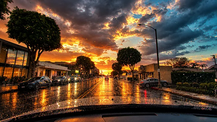 Storm clouds breaking over a wet street at sunset in Fullerton, CA, with reflections on the pavement